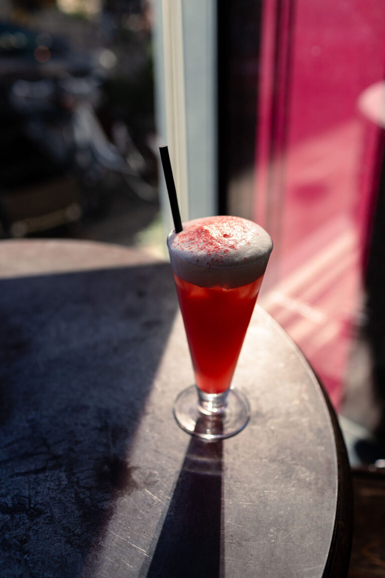 Red cocktail with foam in the sunlight by the window at Bankeråt