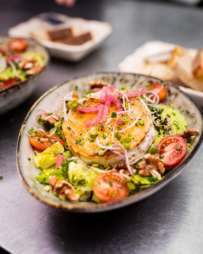 Grilled goat cheese salad with tomatoes, walnuts and pickled red onion at Café Bankeråt
